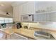 Bright kitchenette featuring a microwave, stainless steel sink, and bar seating in the living area at 1325 Gulf Dr N # 248, Bradenton Beach, FL 34217
