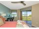 Bright bedroom with a ceiling fan, desk, and balcony overlooking beautiful water views at 1389 Perico Point Cir # 140, Bradenton, FL 34209