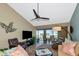 Cozy living room featuring vaulted ceiling, ceiling fan, comfortable seating, and water views from screened lanai at 1389 Perico Point Cir # 140, Bradenton, FL 34209