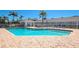 Community pool surrounded by a brick paver patio with lounge chairs and clear blue water at 1389 Perico Point Cir # 140, Bradenton, FL 34209