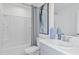 A well-lit bathroom featuring a tub with shower, a modern sink and a decorative painting at 15080 Cuzcorro Ct, Nokomis, FL 34275