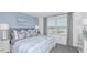 Comfortable bedroom with a gray headboard, large window, blue accent wall and plush carpeting at 15080 Cuzcorro Ct, Nokomis, FL 34275