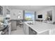Living space with modern decor open to kitchen with white countertops and stainless steel appliances at 15080 Cuzcorro Ct, Nokomis, FL 34275