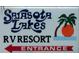 Sarasota Lakes RV Resort entrance sign featuring a palm tree design at 1674 University Pkwy # 389, Sarasota, FL 34243