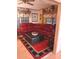 Cozy living room featuring a plush red sofa, hardwood flooring and natural lighting at 1674 University Pkwy # 389, Sarasota, FL 34243