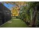Tranquil backyard featuring a lush lawn, mature shade trees, and a putting green for outdoor enjoyment at 1806 Caribbean Dr, Sarasota, FL 34231