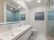 Modern bathroom features dual sinks, sleek fixtures, and a glass-enclosed shower at 1806 Caribbean Dr, Sarasota, FL 34231