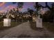 Gated driveway entrance with mature trees and statues, offering privacy and a grand sense of arrival at 1806 Caribbean Dr, Sarasota, FL 34231