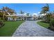 Charming single-story home featuring a lush lawn, mature trees, and a paver driveway leading to a bright entry at 1806 Caribbean Dr, Sarasota, FL 34231