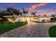 Inviting single-story home features a lush lawn, palm trees, and a paver driveway leading to a bright entry at 1806 Caribbean Dr, Sarasota, FL 34231