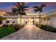 Inviting home featuring a lush lawn, colorful flowers, and a paver walkway leading to a bright entry at 1806 Caribbean Dr, Sarasota, FL 34231