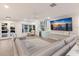 Cozy living room featuring a gray leather sofa, a blue bar area, and a flat-screen TV, perfect for relaxation and entertainment at 1806 Caribbean Dr, Sarasota, FL 34231