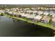 Aerial view of homes in a community on a lake with backyard screened patios at 2183 Nettlebush Ln, Venice, FL 34292
