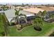 Lush backyard with a screened-in patio, tropical landscaping, and a decorative border, creating a relaxing outdoor living space at 2183 Nettlebush Ln, Venice, FL 34292