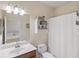 Bathroom with cherry cabinets, shower-tub combo, and neutral tile at 2183 Nettlebush Ln, Venice, FL 34292