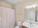 Bright bathroom with a white sink, vanity, and a shower/tub combo with decorative patterned curtain at 2183 Nettlebush Ln, Venice, FL 34292