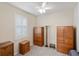 Bedroom with neutral walls and carpet, bright window with shutters, and wood armoires at 2183 Nettlebush Ln, Venice, FL 34292