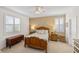 Cozy bedroom showcasing a wooden bed frame, decorative pillows, and natural light from the shuttered windows at 2183 Nettlebush Ln, Venice, FL 34292