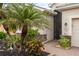 Front entrance featuring decorative shrubs, a paver walkway, and a security screen door at 2183 Nettlebush Ln, Venice, FL 34292