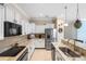 Close-up of a modern kitchen with granite countertops, stainless steel appliances, and stylish pendant lights at 2183 Nettlebush Ln, Venice, FL 34292