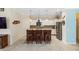Modern kitchen featuring a breakfast bar with wooden stools, stainless steel appliances, and pendant lighting at 2183 Nettlebush Ln, Venice, FL 34292