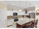 Bright kitchen featuring white cabinets, stainless steel appliances, granite counters and an island with seating at 2183 Nettlebush Ln, Venice, FL 34292
