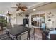 Covered patio features brick pavers, fan, mounted TV and lake view at 2183 Nettlebush Ln, Venice, FL 34292