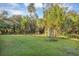 Spacious backyard with lush green grass and mature trees, offering plenty of room for outdoor activities at 2756 Canoe Ln, North Port, FL 34286
