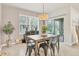 Dining room with stylish light fixture and views of the natural surrounding through sliding glass doors at 2756 Canoe Ln, North Port, FL 34286