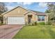 Charming single-story home featuring a manicured lawn, brick driveway, and attached two-car garage at 2756 Canoe Ln, North Port, FL 34286