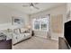 Cozy living room showcasing a comfortable couch, natural light from a large window, and a ceiling fan at 2756 Canoe Ln, North Port, FL 34286