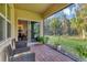 Enclosed patio area with brick flooring, seating, and a view of the green backyard, perfect for relaxing at 2756 Canoe Ln, North Port, FL 34286