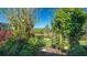 Backyard featuring a pond and lush greenery with colorful flowers in hanging baskets at 315 Londonderry Dr, Sarasota, FL 34240