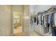 Hallway with view into closet containing a shelf with stored clothing, hats, and bedding at 315 Londonderry Dr, Sarasota, FL 34240