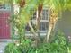 Inviting entryway with a red front door and tropical plants creating a warm, welcoming ambiance at 315 Londonderry Dr, Sarasota, FL 34240