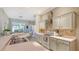 Bright and airy kitchen featuring white cabinets, tile backsplash, and a breakfast bar with a view of the outdoors at 315 Londonderry Dr, Sarasota, FL 34240
