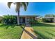 Exterior of a home with a screened porch, manicured lawn, and sidewalk at 3259 Fairhaven Ln # 211, Sarasota, FL 34239