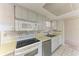 The kitchen has white appliances, white cabinetry, and tile floors at 3259 Fairhaven Ln # 211, Sarasota, FL 34239