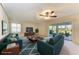 Staged living room with couches, rug, TV, and view through sliding glass doors to the lanai and community landscape at 3259 Fairhaven Ln # 211, Sarasota, FL 34239