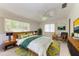 This staged main bedroom features stylish decor, a ceiling fan, and plenty of natural light at 3259 Fairhaven Ln # 211, Sarasota, FL 34239
