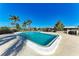 Community pool with inviting blue water and lounge chairs surrounded by palm trees, perfect for relaxation at 3259 Fairhaven Ln # 211, Sarasota, FL 34239
