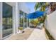 Back patio features a modern seating area, concrete pavers and a blue umbrella at 3319 Mayflower St, Sarasota, FL 34231