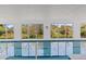 Indoor pool with recessed lights and multiple windows showing the landscaped exterior at 3319 Mayflower St, Sarasota, FL 34231