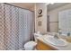 Bathroom with a patterned shower curtain has a sink, toilet, mirror, and other decor at 3514 14Th E Ct, Ellenton, FL 34222
