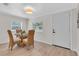 Light-filled dining area featuring a round glass table with woven chairs and a modern light fixture at 3561 Elfers Pkwy, New Port Richey, FL 34655