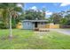 Charming cottage-style home featuring blue siding, a wood deck, and a spacious front yard at 3561 Elfers Pkwy, New Port Richey, FL 34655