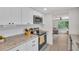 Stylish kitchen showcasing updated appliances, granite countertops, and access to the living room at 3561 Elfers Pkwy, New Port Richey, FL 34655