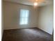 Cozy bedroom features a ceiling fan, plush carpeting, and a bright window at 3799 Countryside Rd, Sarasota, FL 34233