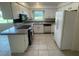 Bright kitchen with white cabinets, tile flooring, breakfast bar, and stainless steel appliances at 3799 Countryside Rd, Sarasota, FL 34233