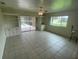 Bright living room with tile floors, ceiling fan, built-in shelving, and screened-in patio view at 3799 Countryside Rd, Sarasota, FL 34233